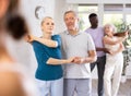 Mature male novice student of fitness studio practices paired Latin American rumba dance Royalty Free Stock Photo