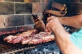 Mature man doing a barbecue. Prodding the meat with a fork