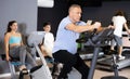 Man doing cardio workout out at gym, training on exercise bikes Royalty Free Stock Photo