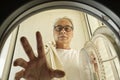 mature man doing laundry at home seen from inside the washing machine Royalty Free Stock Photo