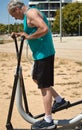 mature man doing sports alone on the street with sports machine Royalty Free Stock Photo