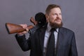 Mature man dressed in suit with tommy gun