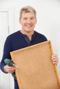 Mature Man Drilling Wall To Hang Picture Frame Royalty Free Stock Photo