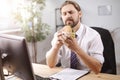 Mature man eating junk food at work Royalty Free Stock Photo