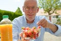 Mature man eating strawberry, outside Royalty Free Stock Photo