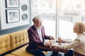 Mature man in elegant suit paying a compliment to his beautiful cheerful wife Royalty Free Stock Photo