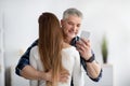 Mature man embracing his wife, stuck in smartphone, not paying attention, texting his lover, going through family crisis Royalty Free Stock Photo