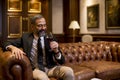 Mature man enjoying a glass of red wine at luxurious apartment Royalty Free Stock Photo