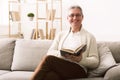 Mature man in eyeglasses reading book, looking at camera Royalty Free Stock Photo