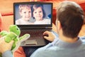 Mature man father lying on sofa and communicate trough video call on laptop with his kids, a little boy and girl showing them toys Royalty Free Stock Photo