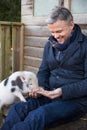 Mature Man Feeding Pet Micro Pig Royalty Free Stock Photo