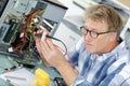 mature man fixing old desktop computer using screwdriver Royalty Free Stock Photo