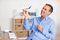 Mature man, freedom and toy plane for travel, vacation and holiday planning with a smile at home. Happy, airplane model