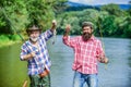 Mature man with friend fishing. Summer vacation. Happy cheerful people. Fishing freshwater lake pond river. Bearded men Royalty Free Stock Photo