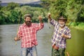 Mature man with friend fishing. Summer vacation. Happy cheerful people. Fishing freshwater lake pond river. Bearded men Royalty Free Stock Photo