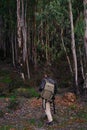 Mature man with hat and jacket entering into the forest