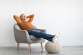 Mature man having rest at home on the chair