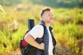 Mature Man Hiking On Sunny Summer Day. Adventure Concept. Solo Travel. Hitch-hiking. Backpacking Trip