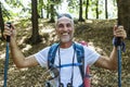 Man hiking in the wood. Handsome middle aged caucasian man with backpack and hiking poles Royalty Free Stock Photo