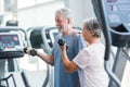 Mature man with his wife doing exercise of biceps at the gym - fitness and healthy lifestyle concept - training their body Royalty Free Stock Photo