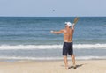 A mature man hits a ball while playing matkot on the beach