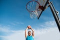 Mature man holding basketball against clear blue sky. Royalty Free Stock Photo