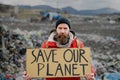 Mature man holding placard poster on landfill, environmental pollution concept. Royalty Free Stock Photo