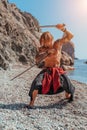 Mature Tattoo Man Holding Swords Ready To Fight on the sea background - Portrait Of A Handsome Muscular Ancient Warrior Royalty Free Stock Photo