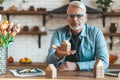 A mature man holds a miniature house in his hands. Loss of money on unprofitable property purchases