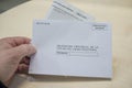 Mature man holds request form and envelope for absentee vote or postal vote Royalty Free Stock Photo