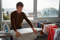 Mature man ironing clothes at home. The concept of maintaining cleanliness and taking care of health. Royalty Free Stock Photo