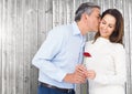 Mature man kissing while giving a red rose to woman Royalty Free Stock Photo