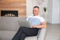 Mature man with laptop sitting on sofa Royalty Free Stock Photo