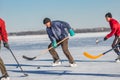 Mature man leading pack while playing hockey on a frozen river