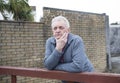 Mature man leaning against a wooden gate outdoors Royalty Free Stock Photo