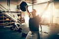 Mature man lifting weights over his head in a gym