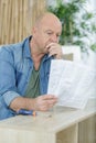 mature man looking at furniture instructions