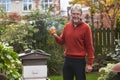 Mature Man Looking At Honey Produced By His Own Bees