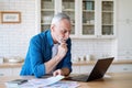 Mature man looking at laptop, calculate expenses, paying bills and taxes online Royalty Free Stock Photo