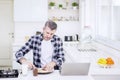 Mature man making breakfast while working Royalty Free Stock Photo