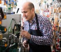 Mature man making duplicates of keys Royalty Free Stock Photo