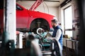 Man mechanic repairing a car in a garage. Royalty Free Stock Photo