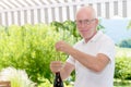 Mature man opening a bottle of red wine Royalty Free Stock Photo