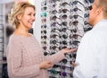 mature man optician client counseling Mature Blonde near the display Sunglasses