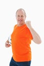 Mature man in orange tshirt cheering holding football