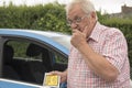 Mature man with parking fine looking annoyed Royalty Free Stock Photo