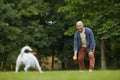 Mature Man Playing with Dog in Park Royalty Free Stock Photo