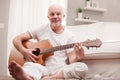 Mature man playing guitar at home Royalty Free Stock Photo