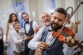 A mature man playing a violin on a wedding reception, bride and groom dancing. Royalty Free Stock Photo