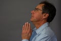 Mature man praying with hands in classic prayer pose Royalty Free Stock Photo